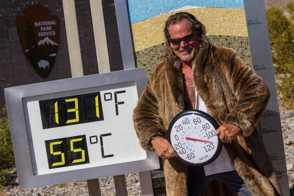 Thor Teigen poses in a fur jacket next to a thermometer displaying a temperature of 131 degrees Fahrenheit / 55 degrees Celsius at the Furnace Creek Visitors Center, in Death Valley National Park, Calif., Sunday, July 7, 2024. Forecasters said a heat wave could break previous records across the U.S., including at Death Valley. (AP Photo/Ty ONeil)