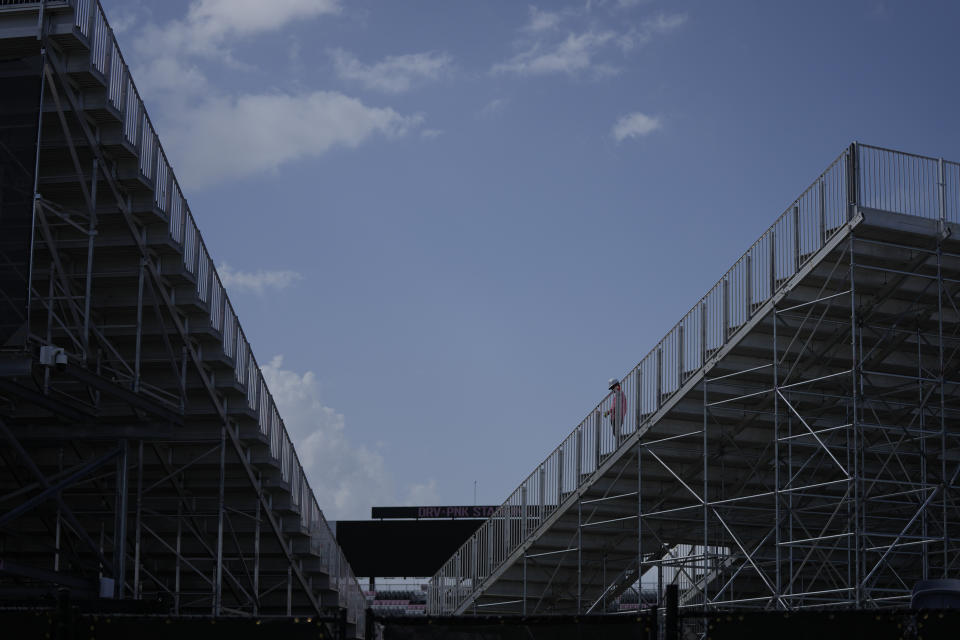 A worker walks on a newly constructed spectator stand, right, alongside some of the previously existing 18,000 seats at DRV Pink stadium, home of Inter Miami MLS soccer team, Tuesday, July 11, 2023, in Fort Lauderdale, Fla. International soccer superstar Lionel Messi is expected to make his debut with the team in a match on July 21, after an introductory event on July 16. (AP Photo/Rebecca Blackwell)