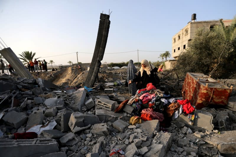 Palestinian woman inspects a house destroyed in an Israeli air strike in the southern Gaza Strip
