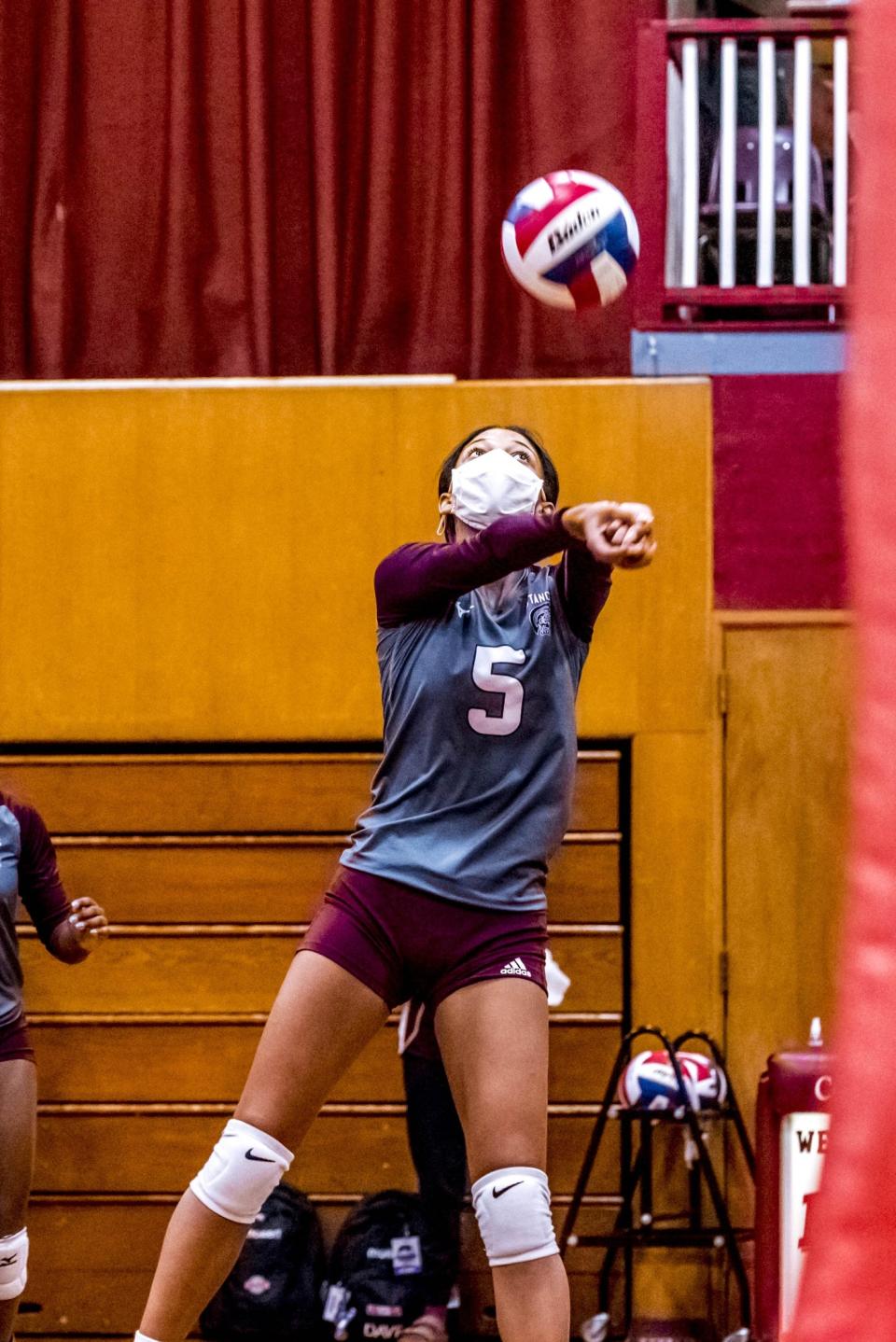 Ali James bumps the ball over the net for Bishop Stang