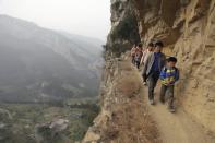 <b>27 mars</b><br> Une marche dangereuse vers l’école : Xy Liangfan escorte les étudiants vers l’école primaire Banpo dans la province de Guizhou en Chine. <br> (Reuters)