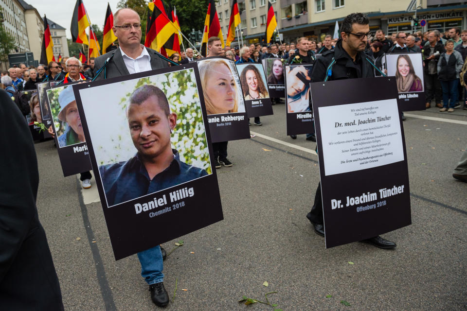 <p>People take part in a march of silence organized by the right-wing Alternative for Germany (AfD) political party and carry German flags and portraits of supposed victims of refugee violence on Sept. 1, 2018 in Chemnitz, Germany. Two refugees, a Syrian and an Iraqi, are accused of having stabbed Chemnitz local Daniel Hillig following an altercation in the early hours of August 26. The death has sparked angry protests by locals as well as right-wing groups that have led to clashes with police and counter-protesters. (Photo: Jens Schlueter/Getty Images) </p>