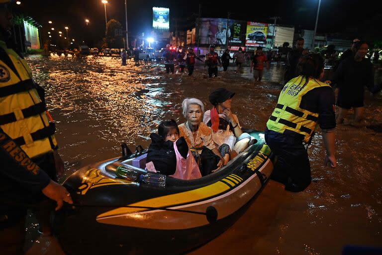 Una familia es rescatada en barco de las crecientes aguas de la inundación en la ciudad de Chiang Rai, en el norte de Tailandia, el 11 de septiembre