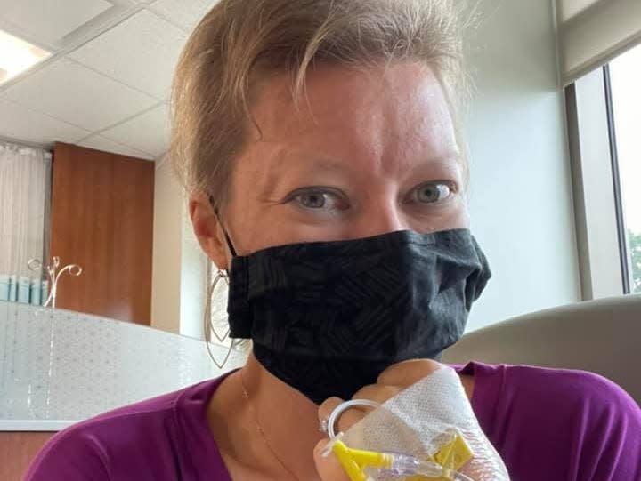 Rachel Garlinghouse at a doctor's office with an IV in her hand and a black surgical mask on