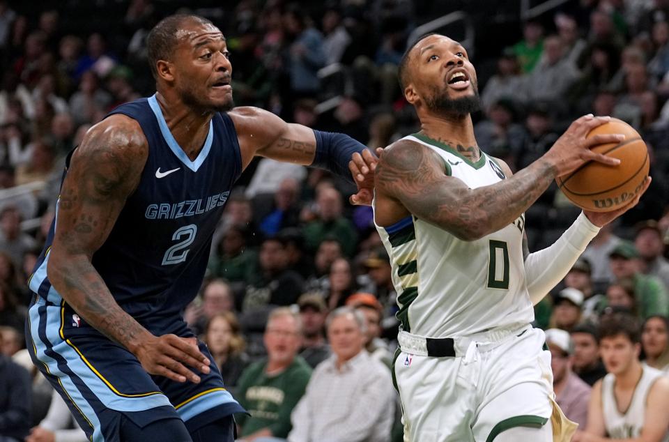 Bucks guard Damian Lillard drives past Grizzlies forward Xavier Tillman during their preseason game at Fiserv Forum.