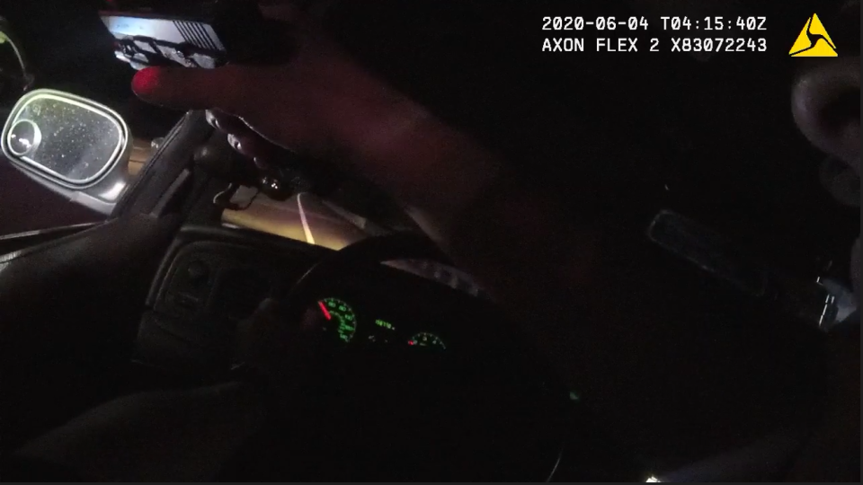 In this still from body camera footage, Louisville Metro Police officer Nathaniel Richardson aims his pistol out of his patrol car's window during a pursuit on June 4, 2020.