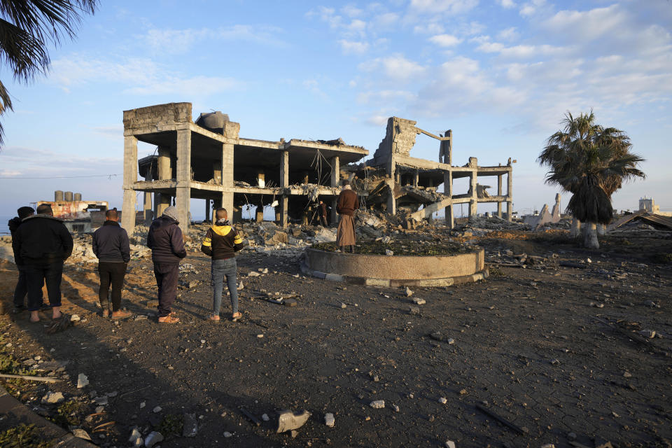 People view the rubble of a destroyed building hit by Israeli airstrikes in Gaza City, Monday, Feb. 13, 2023. Earlier on Monday, the Israeli military said aircraft bombed a Hamas rocket manufacturing site and military installations in the Gaza Strip after Palestinian militants launched four rockets into southern Israel overnight. (AP Photo/Adel Hana)