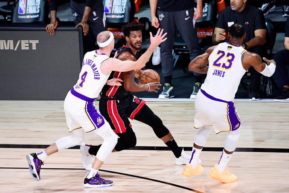 LAKE BUENA VISTA, FLORIDA - OCTOBER 11: Jimmy Butler #22 of the Miami Heat is defended by Alex Caruso #4 of the Los Angeles Lakers and LeBron James #23 of the Los Angeles Lakers during the first quarter in Game Six of the 2020 NBA Finals at AdventHealth Arena at the ESPN Wide World Of Sports Complex on October 11, 2020 in Lake Buena Vista, Florida. NOTE TO USER: User expressly acknowledges and agrees that, by downloading and or using this photograph, User is consenting to the terms and conditions of the Getty Images License Agreement.  (Photo by Douglas P. DeFelice/Getty Images)