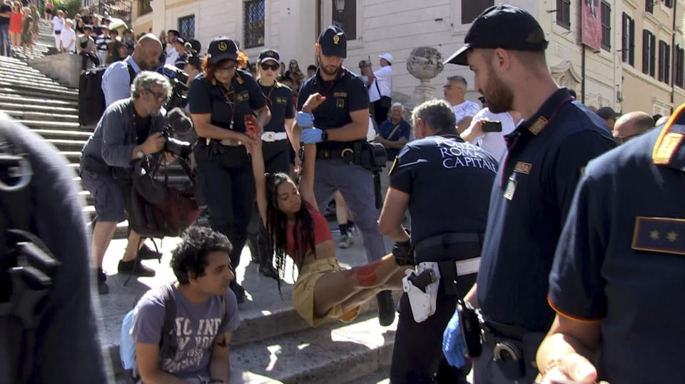 In this frame taken from video Police stop activists dumping red paint on Rome's Spanish Steps as they protest against violence against women, in Rome, Wednesday, June 26, 2024. (Lapresse via AP)