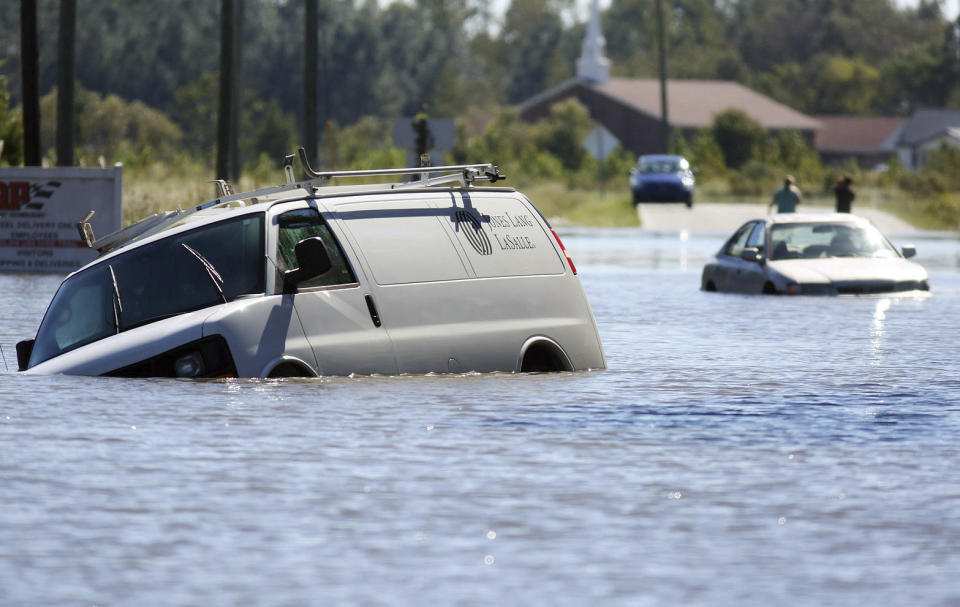 FILE - Several abandoned vehicles sit in flood waters caused by Hurricane Matthew at the intersection of John and Benton streets in Goldsboro, N.C., Monday, Oct. 10, 2016. Nearly six years after extreme rainfall and flooding from Hurricane Matthew damaged many North Carolina homes, some homeowners are still left waiting on repairs. A new bipartisan General Assembly committee tasked with investigating the delays holds its first meeting Wednesday, Sept. 14, 2022, on the four-year anniversary of when Hurricane Florence made landfall in North Carolina. (Casey Mozingo/The Goldsboro News-Argus via AP, File)