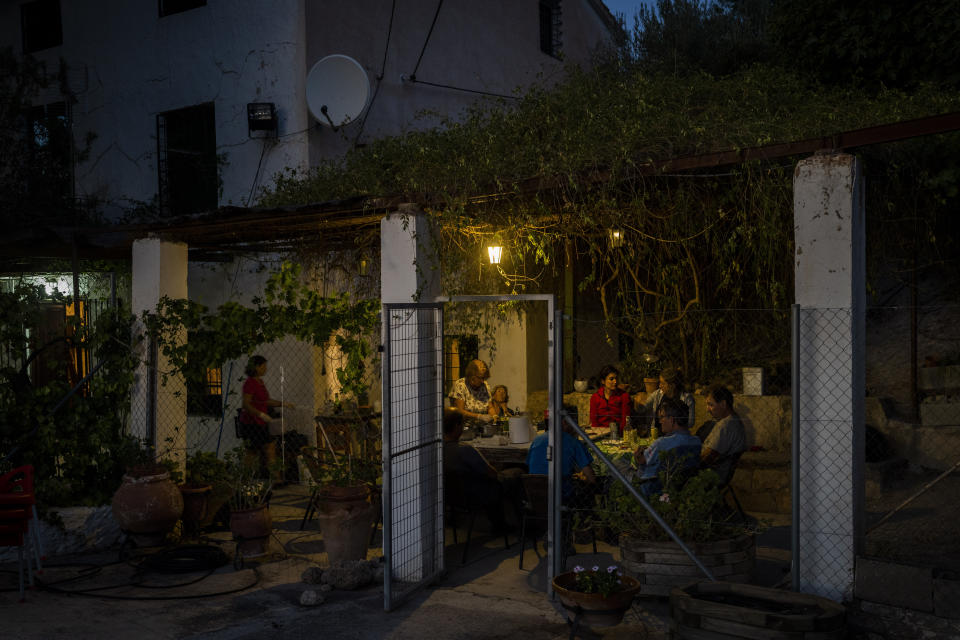 Friends and relatives of the Palop family have dinner after the olive harvest in the southern town of Quesada, a rural community in the heartland of Spain's olive country, Saturday, Oct. 29, 2022. (AP Photo/Bernat Armangue)