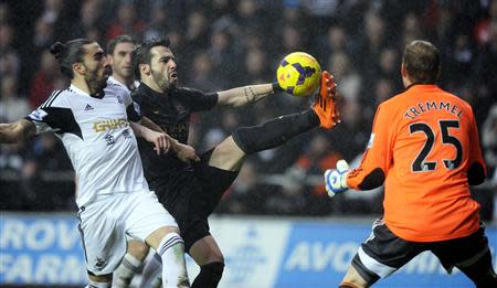 Swansea City's Chico Flores (L) challenges Manchester City's Alvaro Negredo (C) during their English Premier League soccer match at the Liberty Stadium in Swansea, Wales, January 1, 2014. REUTERS/Rebecca Naden