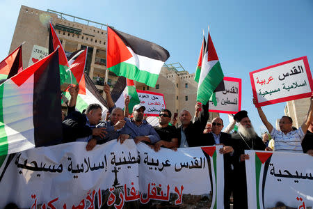 FILE PHOTO: Palestinians, among them Adnan Husseini (3-rd R), the Palestinian Authority-appointed mayor of Jerusalem, participate in protest against the opening of the new U.S. embassy in Jerusalem May 14, 2018. Banner reads in Arabic "Jerusalem Arab, Palestinian, Islamic and Christian" and "No to the Moving of the American Embassy". REUTERS/Ammar Awad/File Photo