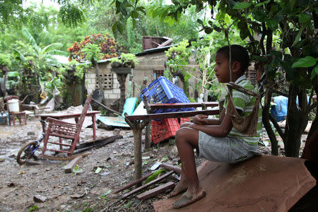 A child watches the damage done by an overflow of the Soco River in El Seibo, Dominican Republic, September 22, 2017. REUTERS/Ricardo Rojas