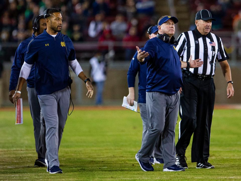 Notre Dame defensive coordinator Marcus Freeman looks at Notre Dame head coach Brian Kelly as he talks to an official during the Notre Dame vs. Stanford NCAA football game Saturday, Nov. 27, 2021 at Stanford Stadium in Palo Alto, Calif.