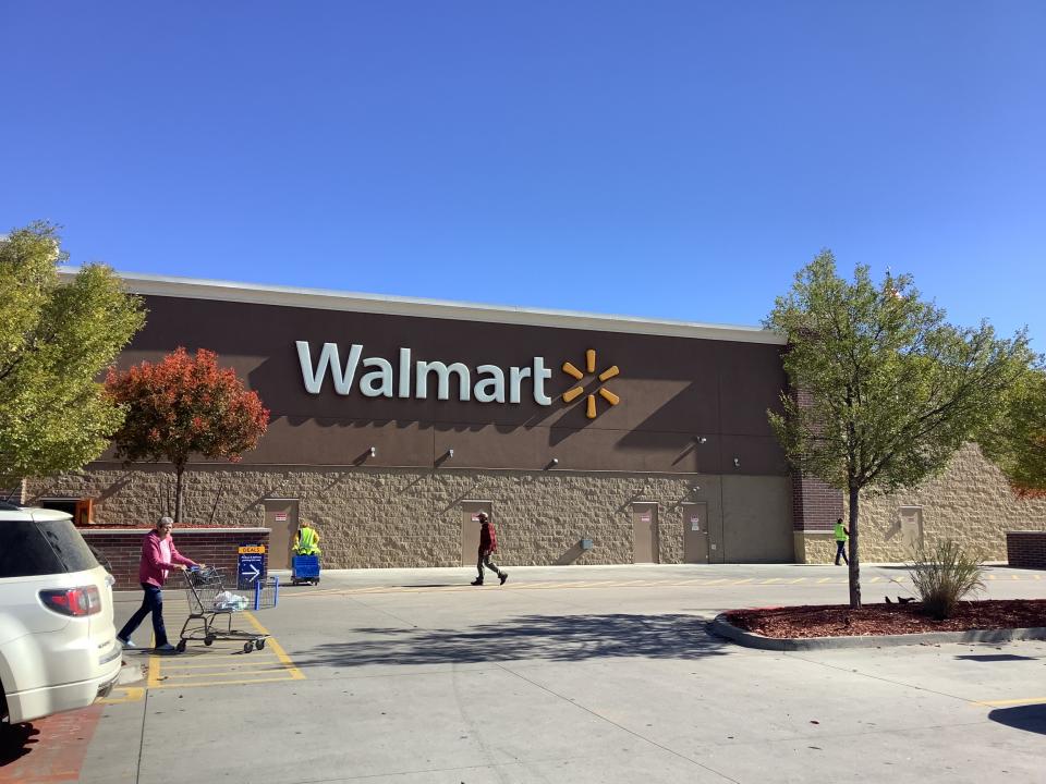 Workers and customers hurry about in this exterior shot of a Walmart supercenter lot in 2021.