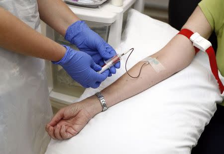 Volunteer Ruth Atkins has blood taken before receiving an injection of the Ebola vaccine at the Oxford Vaccine Group Centre for Clinical Vaccinology and Tropical Medicine (CCVTM) in Oxford, southern England September 17, 2014. REUTERS/Steve Parsons/Pool