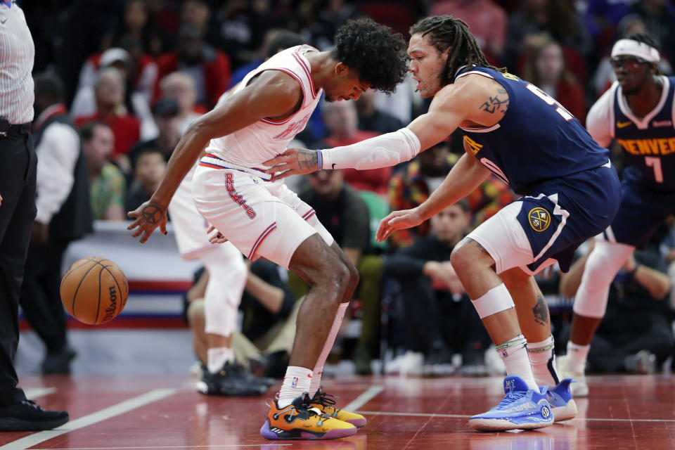 Houston Rockets guard Jalen Green, left, loses the ball out of bounds under pressure from Denver Nuggets forward Aaron Gordon, right, during the first half of an NBA basketball In-Season Tournament game Friday, Nov. 24, 2023, in Houston. (AP Photo/Michael Wyke)