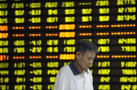 An investor stands in front of an electronic board showing stock information at a brokerage house in Huaibei, Anhui province, July 27, 2015. REUTERS/Stringer