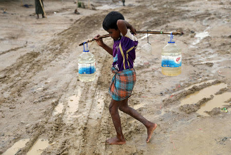 A Rohingya refugee boy carries bottles with water at a refugee camp in Cox's Bazar, Bangladesh October 8, 2017. REUTERS/Mohammad Ponir Hossain