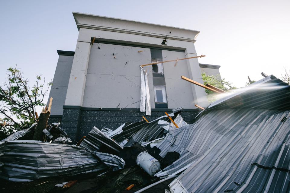 The Hampton Inn in Bartlesville, Oklahoma, was damaged in a confirmed tornado on May 6, 2024. The building is shown on May 7 with roof debris stuck on its side.