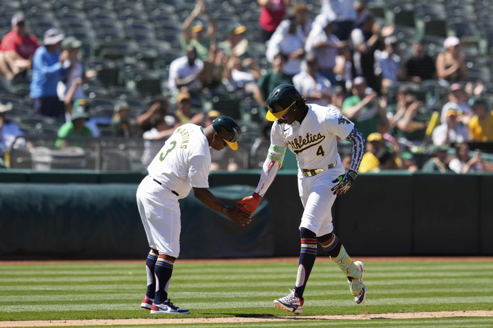 Oakland Athletics' Lawrence Butler, right, celebrates with third base coach Eric Martins, left, after hitting a solo home run against the Los Angeles Angels during the eighth inning of a baseball game Thursday, July 4, 2024, in Oakland, Calif. (AP Photo/Godofredo A. Vásquez)