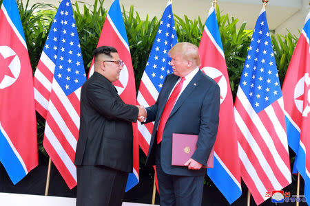 U.S. President Donald Trump shakes hands with North Korean leader Kim Jong Un at the Capella Hotel on Sentosa island in Singapore in this picture released on June 12, 2018 by North Korea's Korean Central News Agency. KCNA via REUTERS