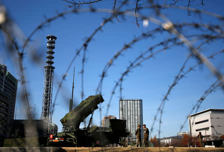 Members of the Japan Self-Defence Forces stand guard near Patriot Advanced Capability-3 (PAC-3) land-to-air missiles, deployed at the Defense Ministry in Tokyo December 7, 2012. REUTERS/Issei Kato/File Photo