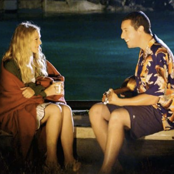 a couple sitting on a bench by a body of water