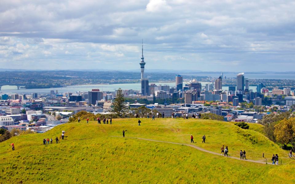 People walk around the volcanic crater on Mount Eden. New Zealand, North Island, Auckland 