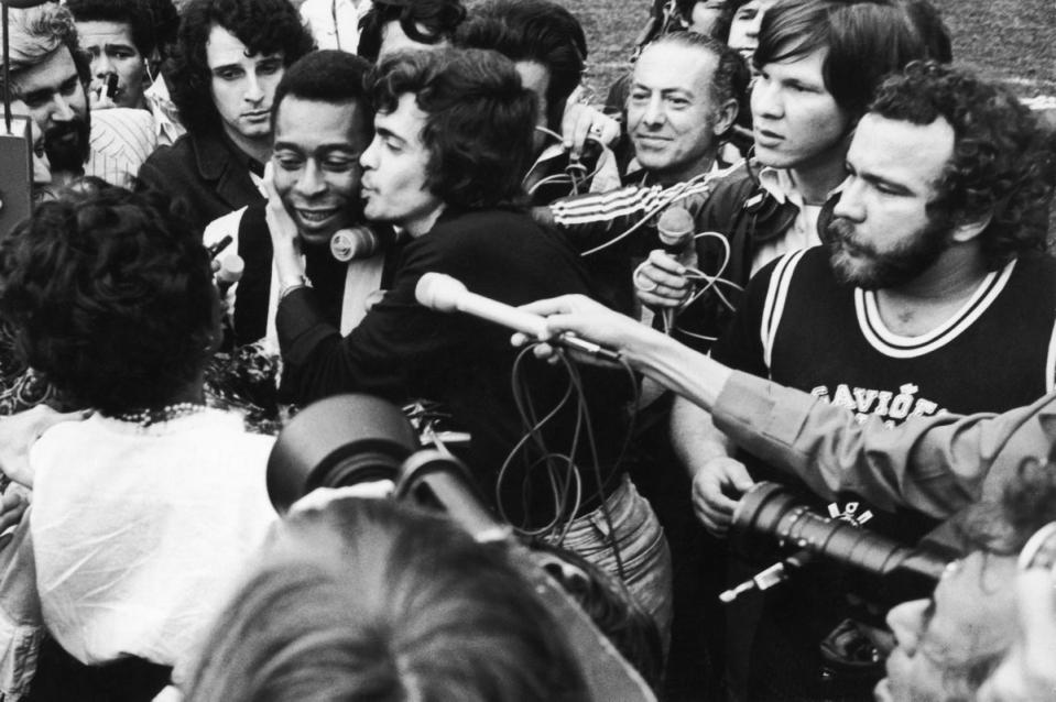Pele is surrounded by players and press as he leaves the pitch after his last match in an 18 year spell at Santos, 8th October 1974. He retired from the game, Santos vs Ponte Preta, due to a thigh injury. (Getty Images)
