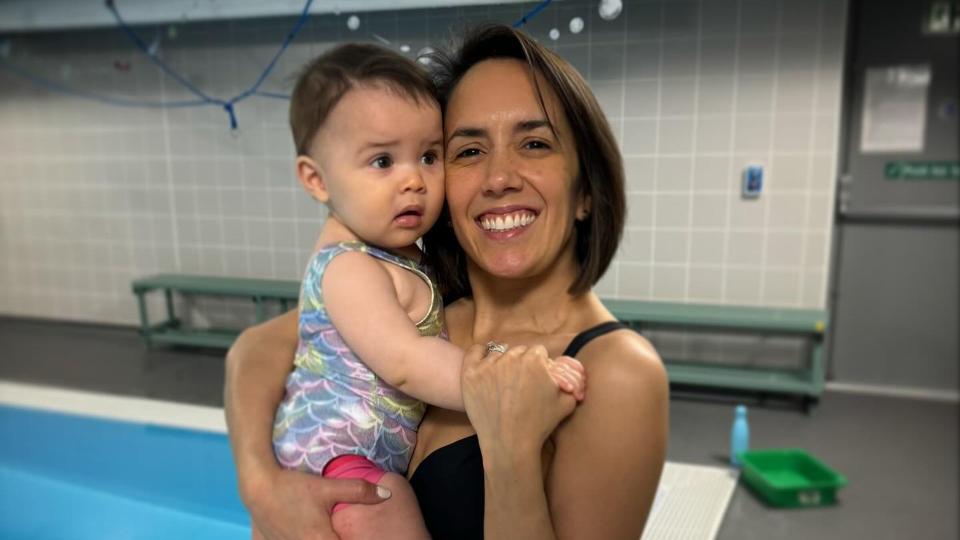 janette holding Lyra by swimming pool