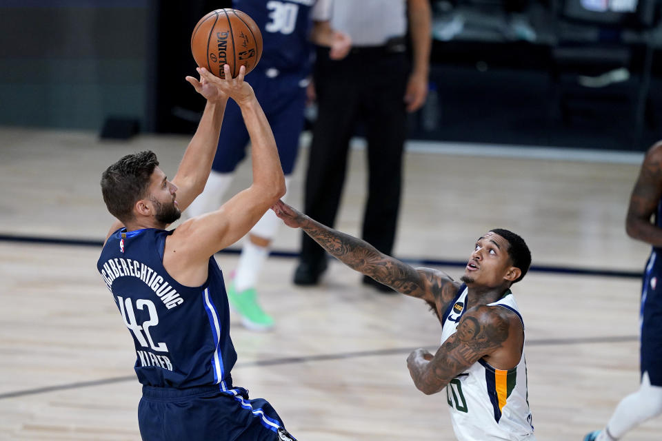 Dallas Mavericks' Maxi Kleber (42) shoots as Utah Jazz's Jordan Clarkson (00) defends during the first half of an NBA basketball game Monday, Aug. 10, 2020, in Lake Buena Vista, Fla. (AP Photo/Ashley Landis, Pool)