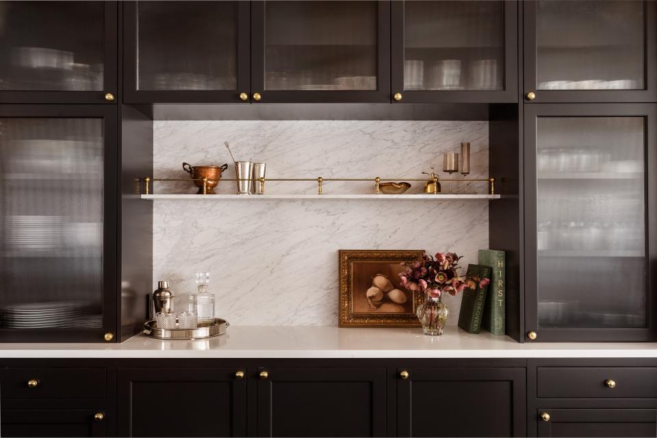 AFTER: The marble backsplash is the focal point of the space and reeded glass lends an airy feel while still providing some coverage.