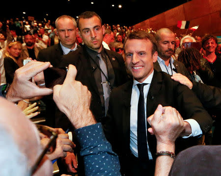 Emmanuel Macron (R), head of the political movement En Marche ! (Onwards !) and candidate for the 2017 presidential election, arrives to attend a campaign rally in Besancon, France, April 11, 2017. REUTERS/Robert Pratta