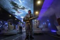 A volunteer with the Blue Sky Rescue team performs disinfecting of the virtual reality theater in a cinema before it reopens for business in Beijing Friday, July 24, 2020. Theaters in China, the world's second largest movie market, this week reopened from the coronavirus shut down with theaters limited to 30% capacity. (AP Photo/Ng Han Guan)