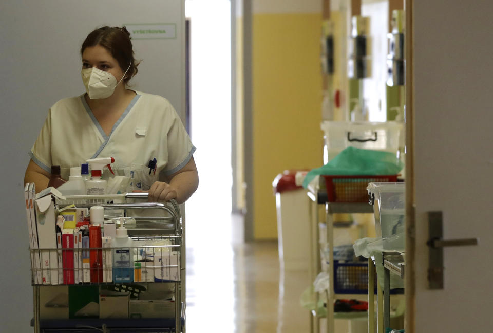 Karolina Repikova, a 22-year-old student at a vocational school, volunteers at a hospital in Kyjov, Czech Republic, Thursday, Oct. 22, 2020. With cases surging in central Europe, some countries are calling in soldiers, firefighters, students and retired doctors to help shore up buckling health care systems. (AP Photo/Petr David Josek)