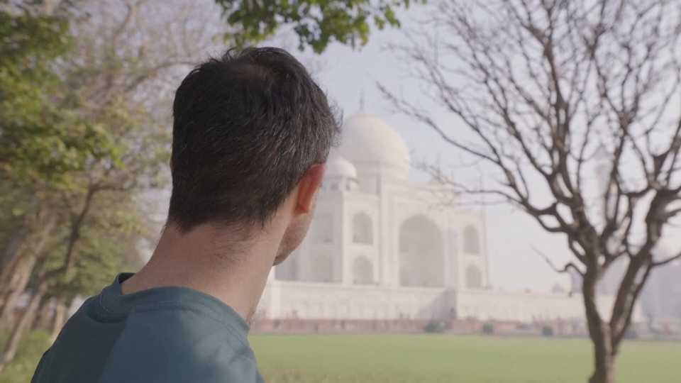 A still image of Jamie McDonald posing in front of the Taj Mahal grabbed from video.