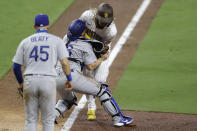 San Diego Padres' Fernando Tatis Jr., right, collides with Los Angeles Dodgers catcher Will Smith, center, as he is tagged out attempting to score from third base on a line out by Manny Machado during the seventh inning of a baseball game Monday, Aug. 3, 2020, in San Diego. Los Angeles Dodgers first baseman Matt Beaty (45) looks on at left. (AP Photo/Gregory Bull)