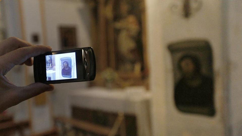 Alguien tomando una foto del Ecce Homo con el celular