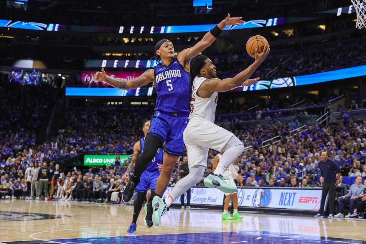 Cavaliers guard Donovan Mitchell goes to the basket in front of Magic forward Paolo Banchero during the second half of Game 6 of a first-round playoff series, May 3, 2024, in Orlando.