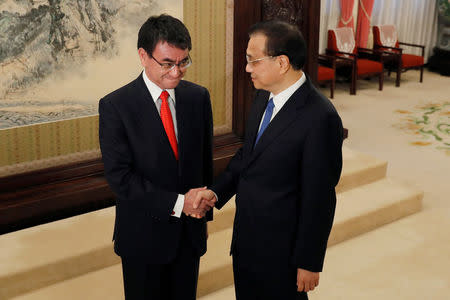 Japanese Foreign Minister Taro Kono, left, and Chinese Premier Li Keqiang shake hands before their meeting at the Zhongnanhai Leadership Compound in Beijing, Sunday, Jan. 28, 2018. REUTERS/Andy Wong/Pool