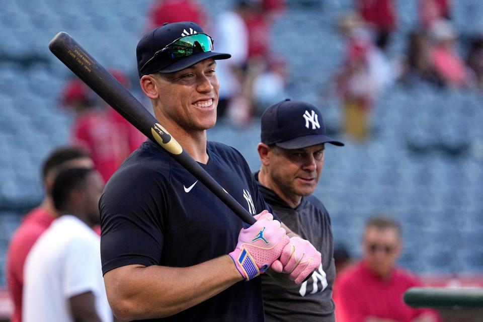New York Yankees' Aaron Judge, left, smiles during batting practice as manager Aaron Boone stands by prior to a game against the Los Angeles Angels Tuesday, July 18, 2023, in Anaheim, Calif. (AP Photo/Mark J. Terrill)