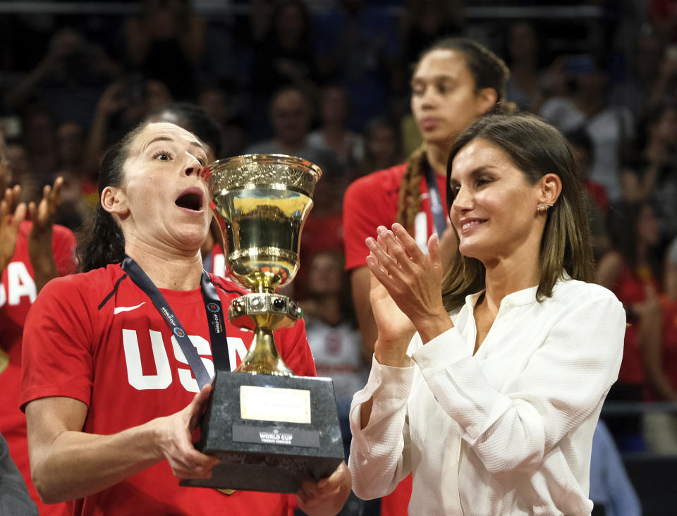 FILE - Sue Bird of the United States, left, lifts the trophy as Queen Letizia applauds after winning the Women's Basketball World Cup final match against Australia in Tenerife, Spain, Sunday, Sept. 30, 2018. Spain’s Queen Letizia turned 50 on Thursday, Sept. 15, 2022. Spain is taking the opportunity to assess its scarred monarchy and ponder how the arrival of a middle-class commoner may help shake one of Europe’s most storied royal dynasties into a modern and more palatable institution. (AP Photo/Andres Gutierrez, File)