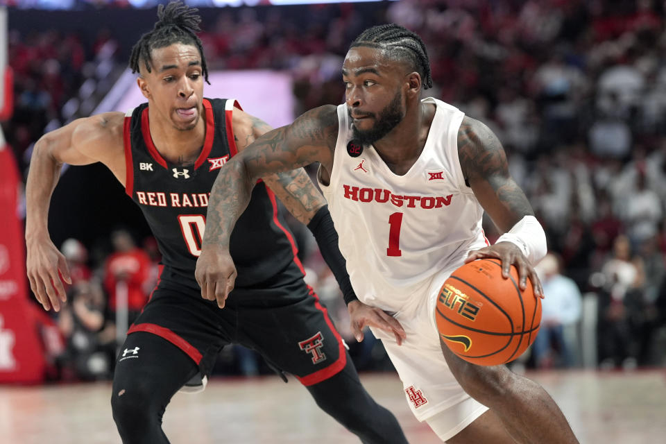 Houston's Jamal Shead (1) drives toward the basket as Texas Tech's Chance McMillian (0) defends during the second half of an NCAA college basketball game Wednesday, Jan. 17, 2024, in Houston. (AP Photo/David J. Phillip)
