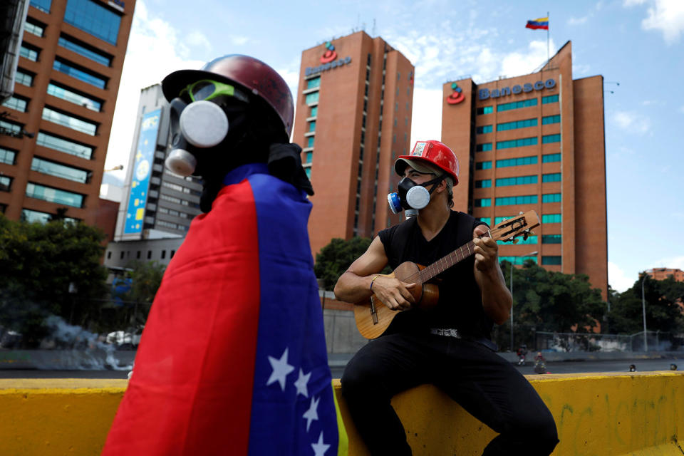 <p>A demonstrator plays a guitar during clashes at a march to the state Ombudsman’s office in Caracas, Venezuela May 29, 2017. (Photo: Carlos Garcia Rawlins/Reuters) </p>