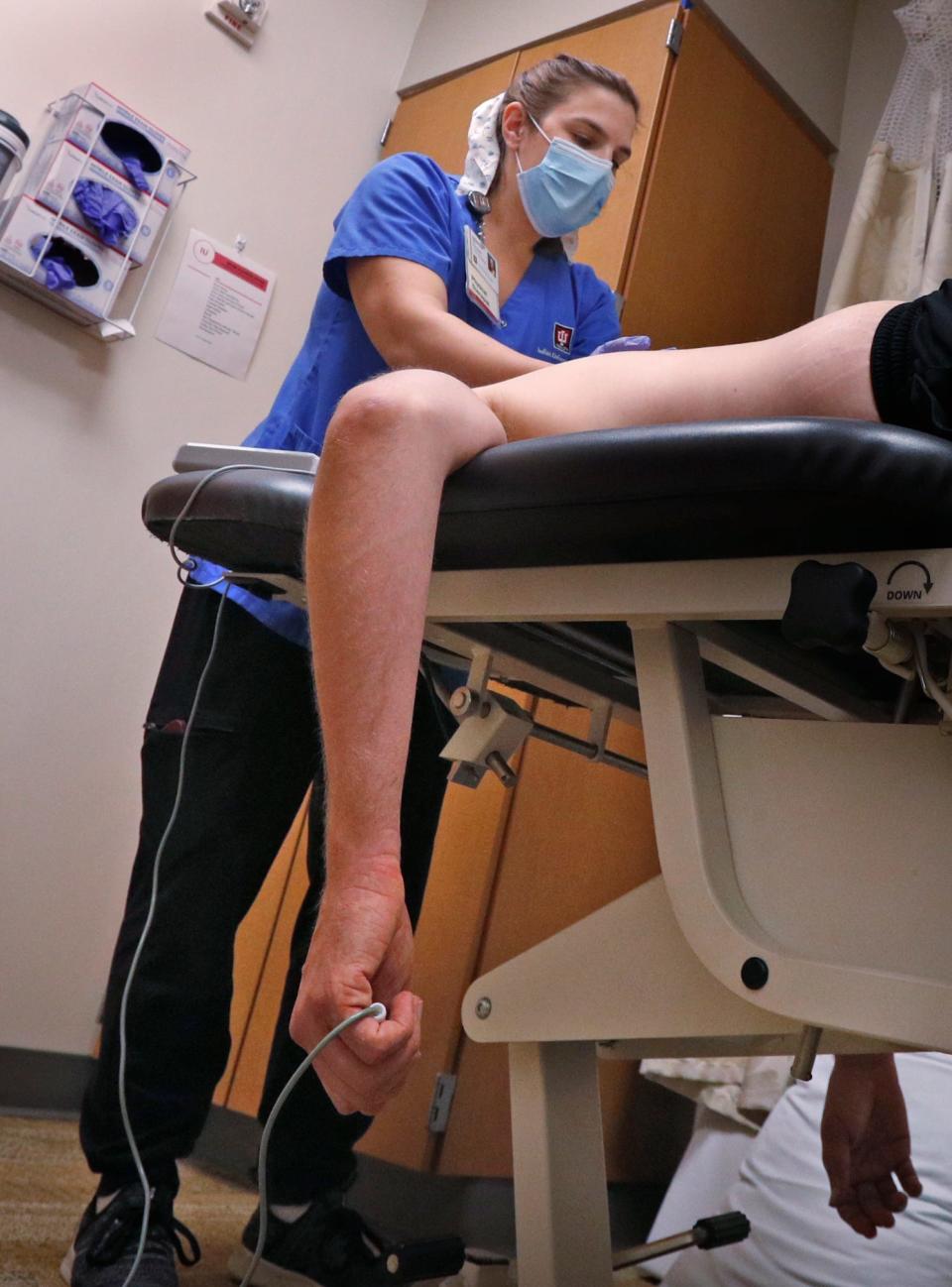 Physical Therapist Katherine Morin, left, works on Adam Bodony during a physical therapy session Tuesday, Aug. 17, 2021 at IU Health North Hospital. He developed persistent symptoms after a bout with COVID in 2020. He was not sick enough to be hospitalized at the time of his acute infection, but since having COVID, he has had a series of health conditions, many of them connected to what an IU Health doctor ascribed to long COVID.