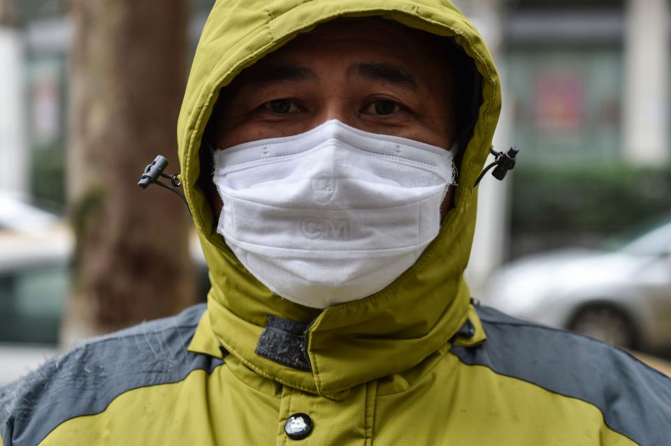 A man who works as a volunteer taking medicine for those who need it waits outside a pharmacy in Wuhan on January 26, 2020, the Chinese city at the epicenter of the coronavirus outbreak | HECTOR RETAMAL/AFP via Getty Images