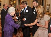 <p> Elle Macpherson looked modest next to Queen Elizabeth&apos;s bright purple ensemble during an event at Buckingham Palace in 2011. The Australian supermodel wore a monochrome outfit, pairing a beige dress with a soft pink handbag. </p>