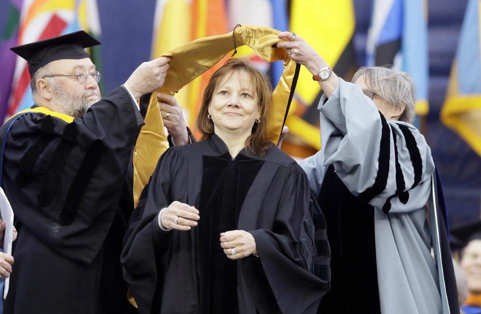 General Motors CEO Mary Barra, center, is conferred an honorary Doctor of Engineering degree before addressing the University of Michigan graduates at a commencement ceremony Saturday, May 3, 2014 in Ann Arbor, Mich. Barra, the first woman to lead a major automaker, took the top spot at GM in January, just as a deadly ignition switch problem was starting to surface. Barra urged the students to be honest in every aspect of their lives, and to use their optimism and propensity for inclusion to rethink outdated assumptions and expose and correct injustice. (AP Photo/Carlos Osorio)